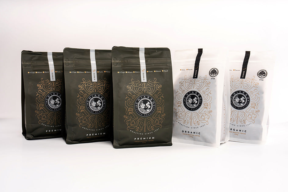 Five bags of Chiasso coffee, each labeled with different coffee blend names such as Milano, Dolce, Pascolo, Metro, and Il Capo.